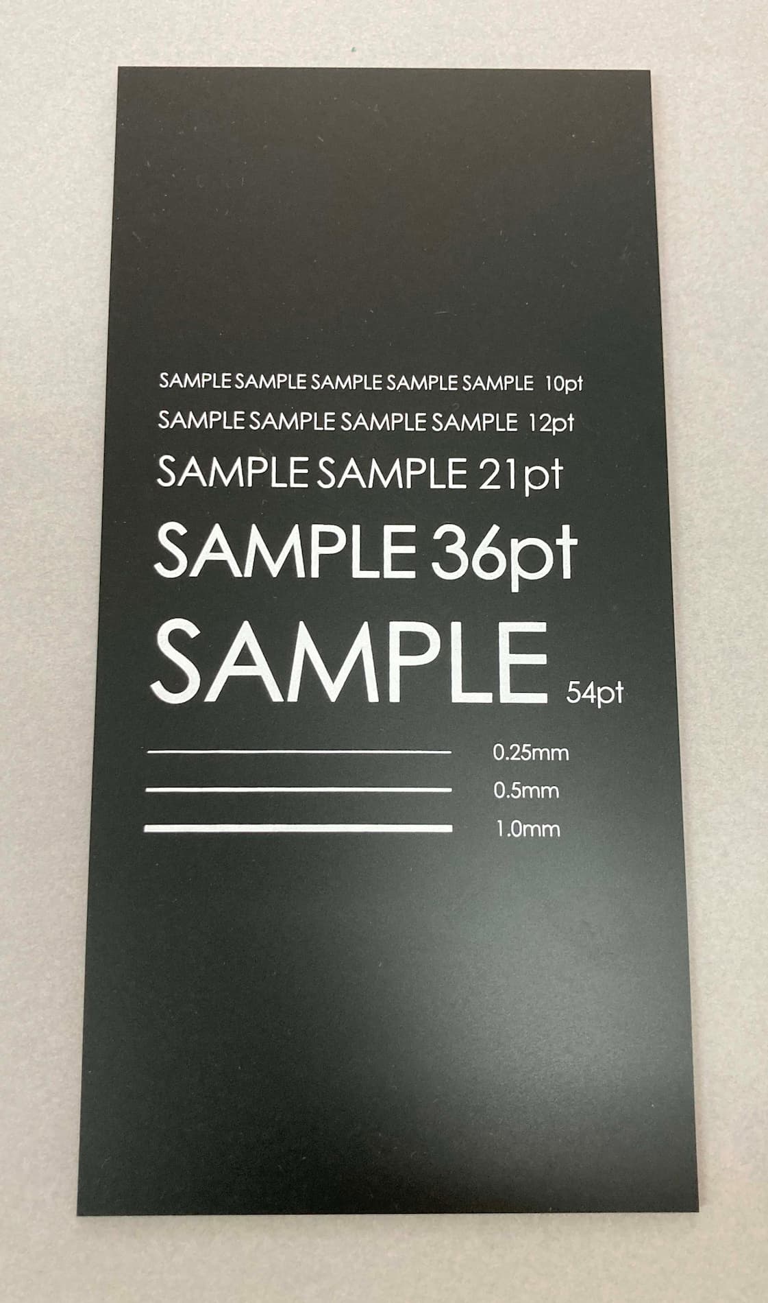 黒のアクリルプレートに文字や線を印刷いたします。|(有)大石孔版