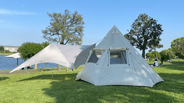 広い窓からは光と風が入る。解放感を求めたティピーテントとタープで緑